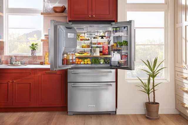 Front view of an opened KitchenAid refrigerator with an in-door ice maker